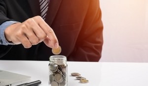 Hand putting mix coins and seed in clear bottle and copyspace, B