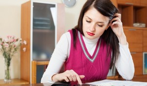 serious housewife filling in utility payments bills