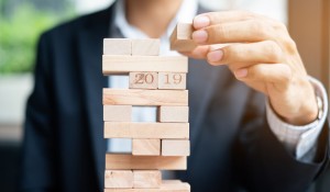 businessman-hand-placing-or-pulling-wooden-block-on-the-tower_42256-528