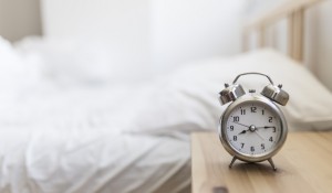 despertador-na-mesa-de-madeira-no-quarto_23-2147911984