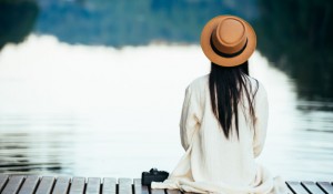 mulher-solitaria-sentado-na-jangada-a-beira-mar_1150-7466