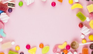 various-sweet-candies-forming-frame-pink-background_23-2147921695