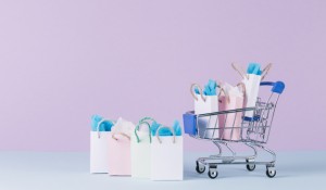 filled-miniature-cart-with-paper-shopping-bags-front-pink-background_23-2147892202