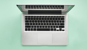 elevated-view-open-laptop-green-background_23-2148213955