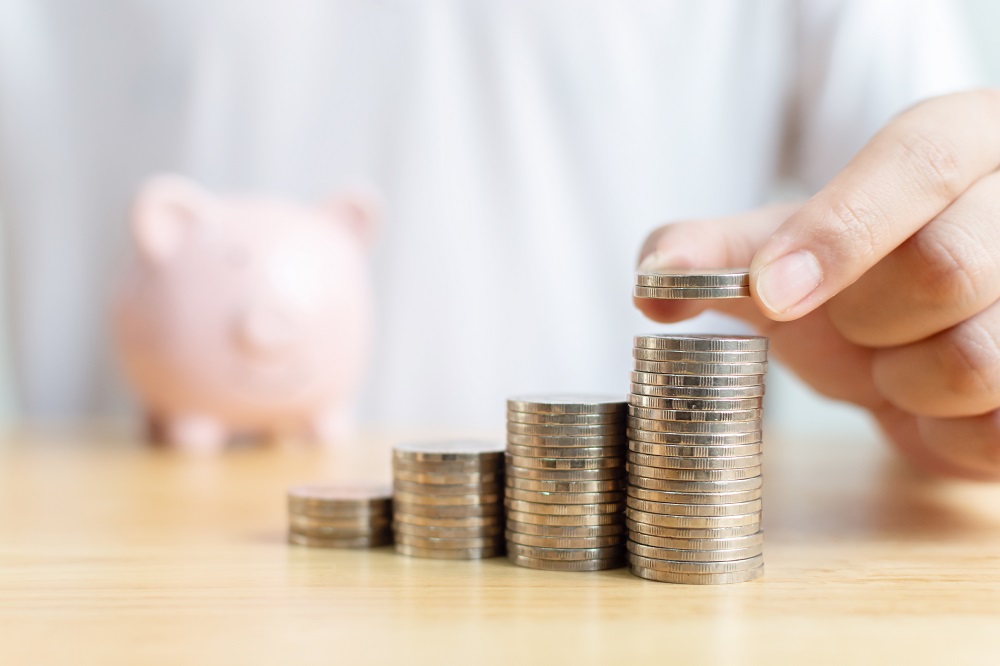 Concept save money financial business investment. Hand of male putting coins stack step growing growth value with piggy bank