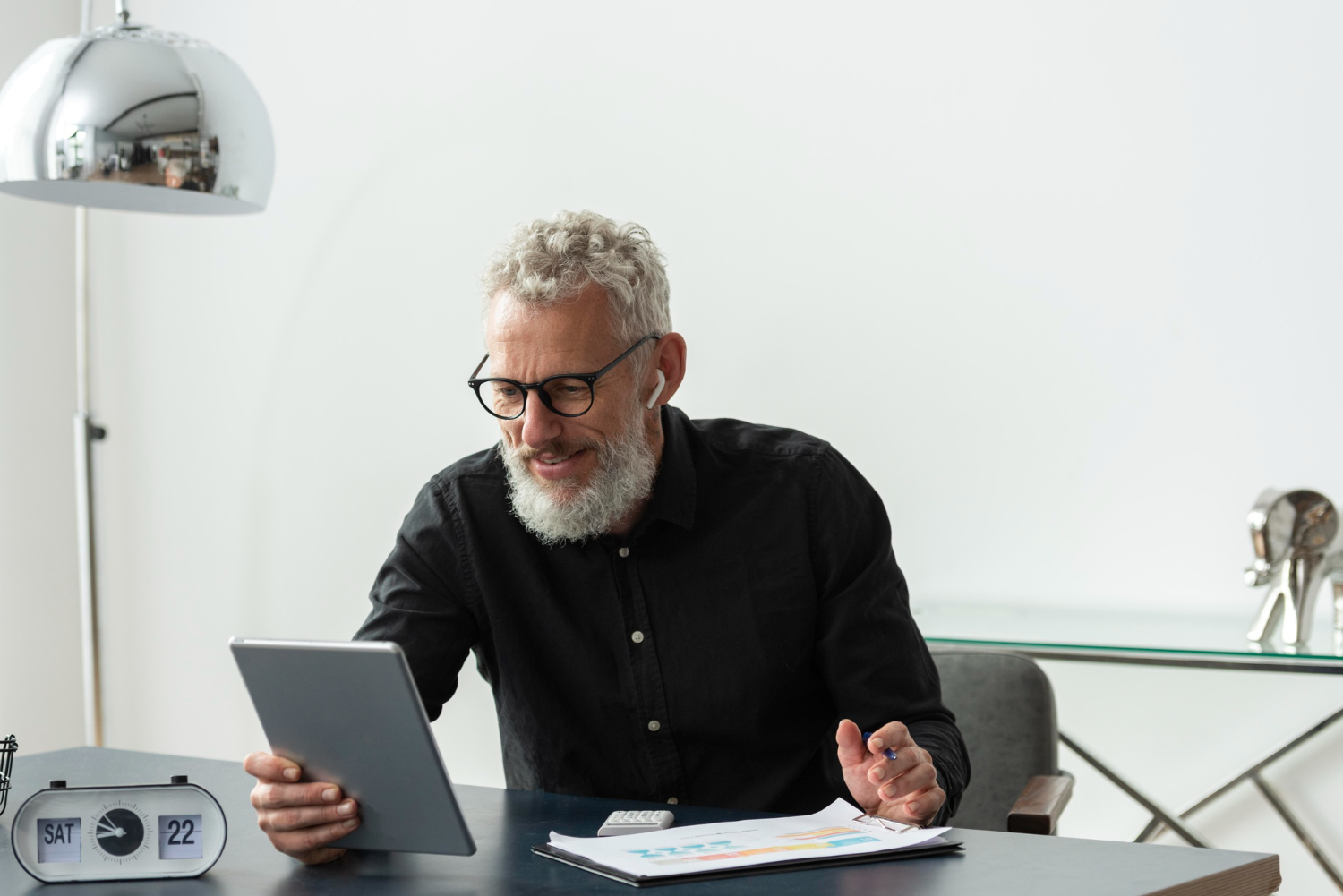 senior-man-with-glasses-home-studying-while-using-tablet
